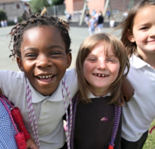 Două fete tinere în uniformă imită periajul dinților, cu perii din carton