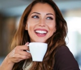 Femeie zâmbitoare care bea cafea