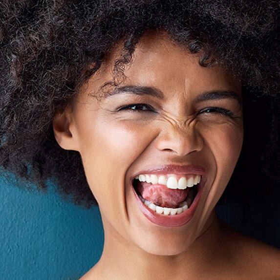 smiling woman licking her white teeth 